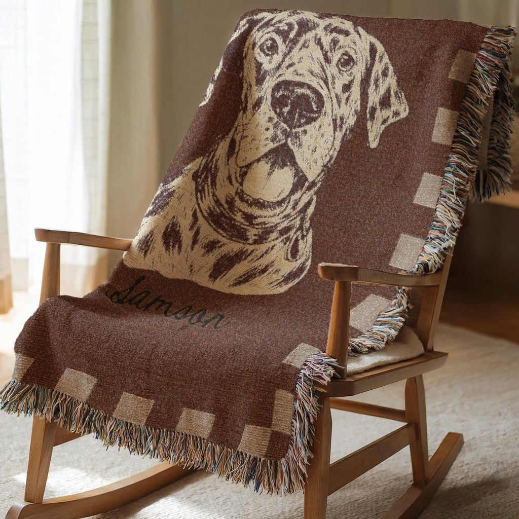 Wooden rocking chair with a brown blanket featuring a dog design and name