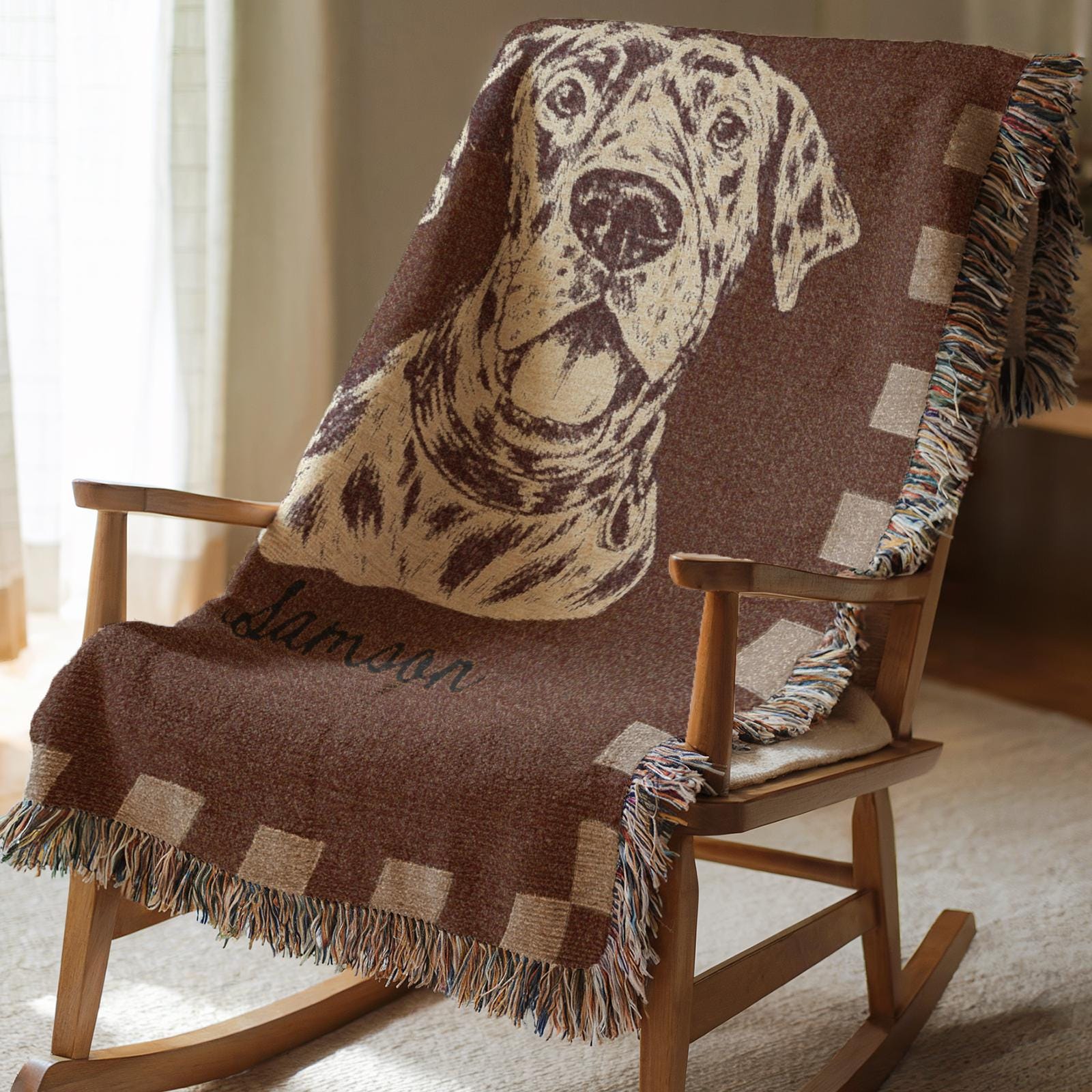 Wooden rocking chair with a brown blanket featuring a dog design and name