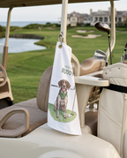 Golf cart with a towel featuring a pointer dog and text hanging from the seat