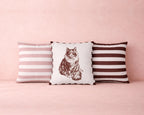 Three pillows with striped and cat print designs on a pink background