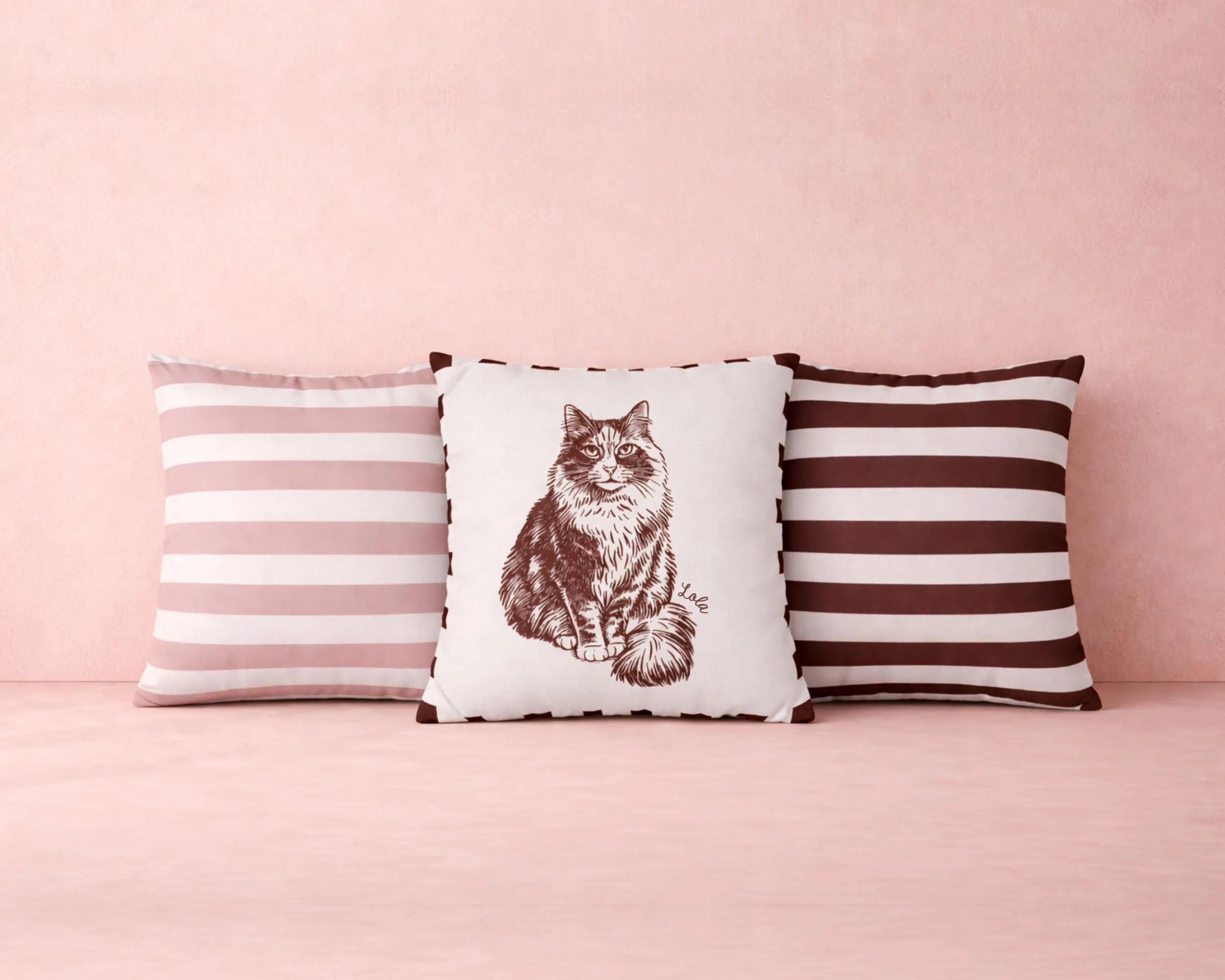 Three pillows with striped and cat print designs on a pink background