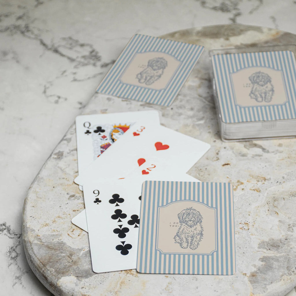 Playing cards with dog illustrations on a marble surface