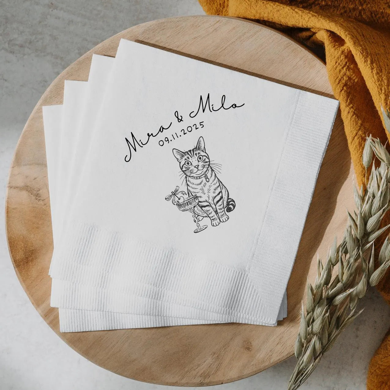 White napkins with a cat illustration and text on a wooden surface