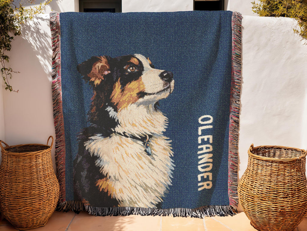 Blanket with    australian shepherd illustration and'text, draped over a surface with wicker baskets.