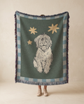 Person holding a blanket with a dog illustration and star pattern in a room.