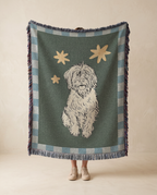 Person holding a blanket with a dog illustration and star pattern in a room.