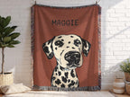 Blanket with a dalmatian dog illustration and 'Maggie' text, hanging on a white brick wall.