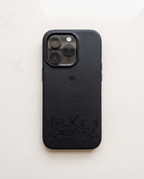 A black textured leather phone case with an embossed puppy design along the bottom and a small heart logo, shown on a light off-white background.