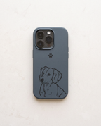 A blue leather phone case featuring a black line art illustration of a dachshund and a small black paw print, shown on a light beige textured background.