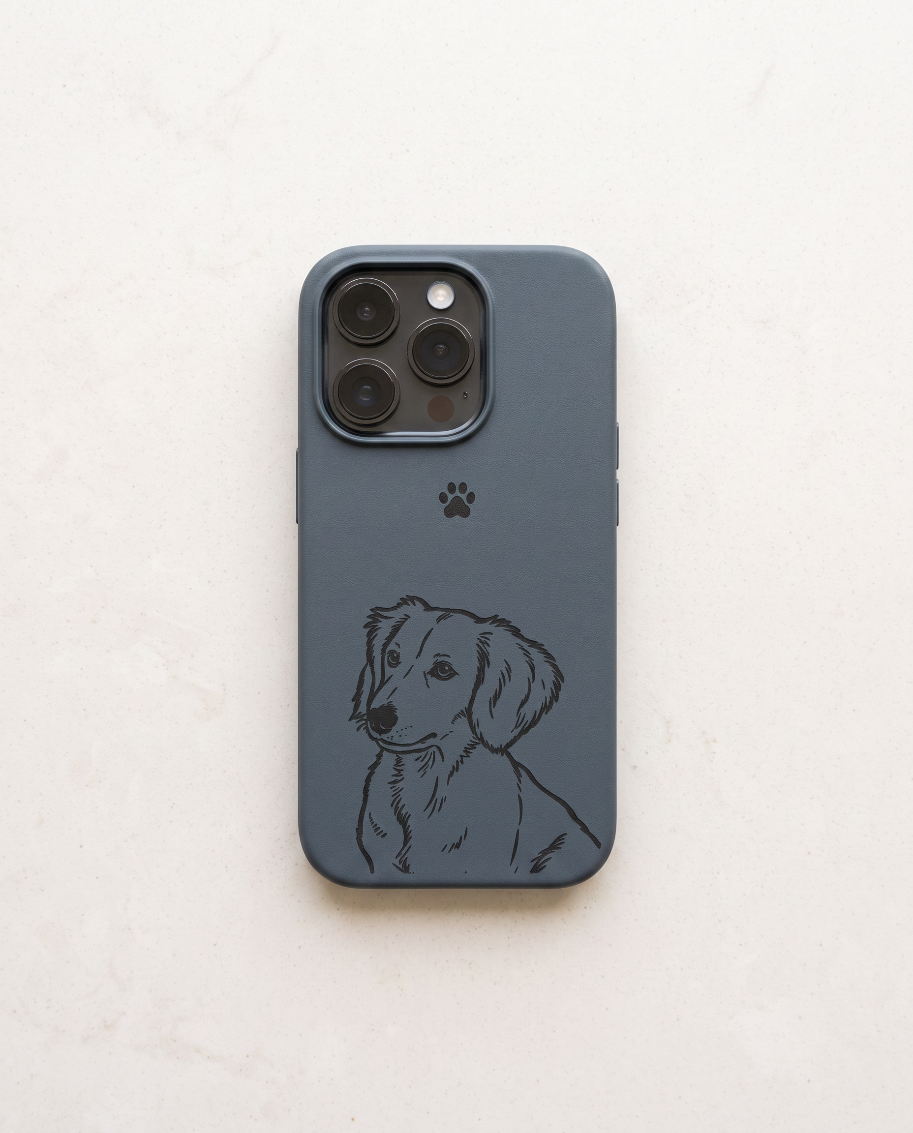 A blue leather phone case featuring a black line art illustration of a dachshund and a small black paw print, shown on a light beige textured background.