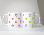 Two white mugs with custom pet drawings with rose and tennis ball patterns on a white surface.
