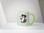 Mug with a dog illustration and green handle on a white surface