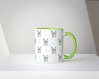 Mug with green handle featuring dog pattern on a white surface