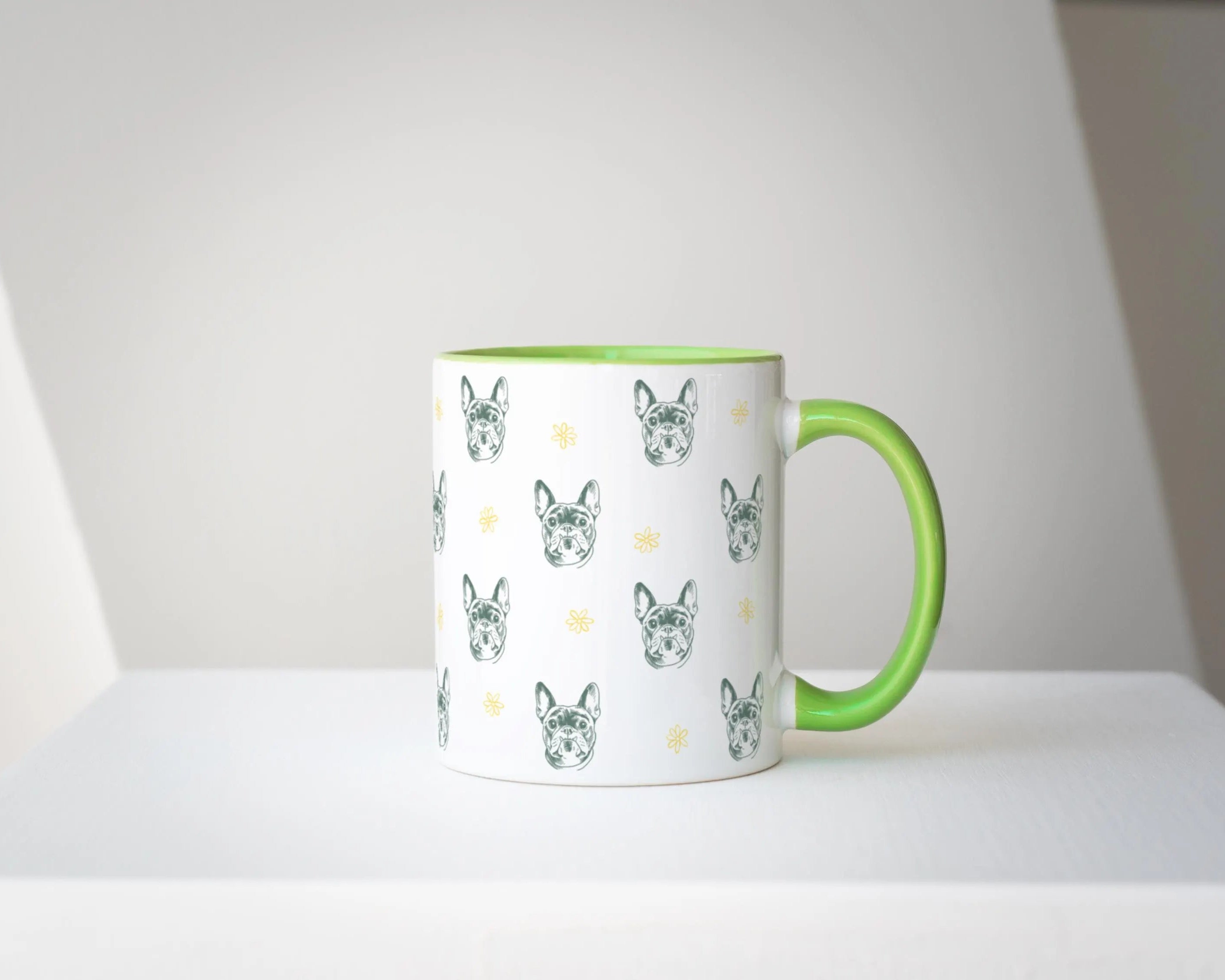 Mug with green handle featuring dog pattern on a white surface