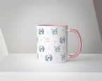 Custom mug with cat and dog illustrations and pink handle on a white surface