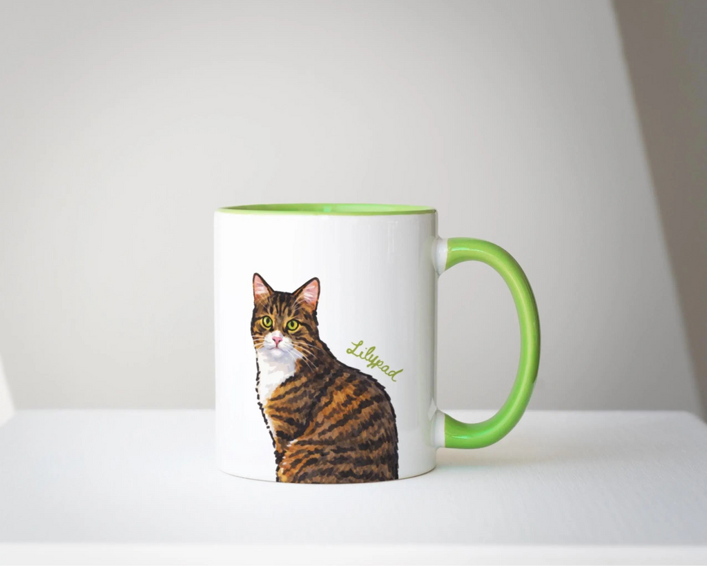 Mug with a cat illustration and green handle on a white background