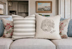 Decorative pillows with dog and text on a sofa with a painting in the background