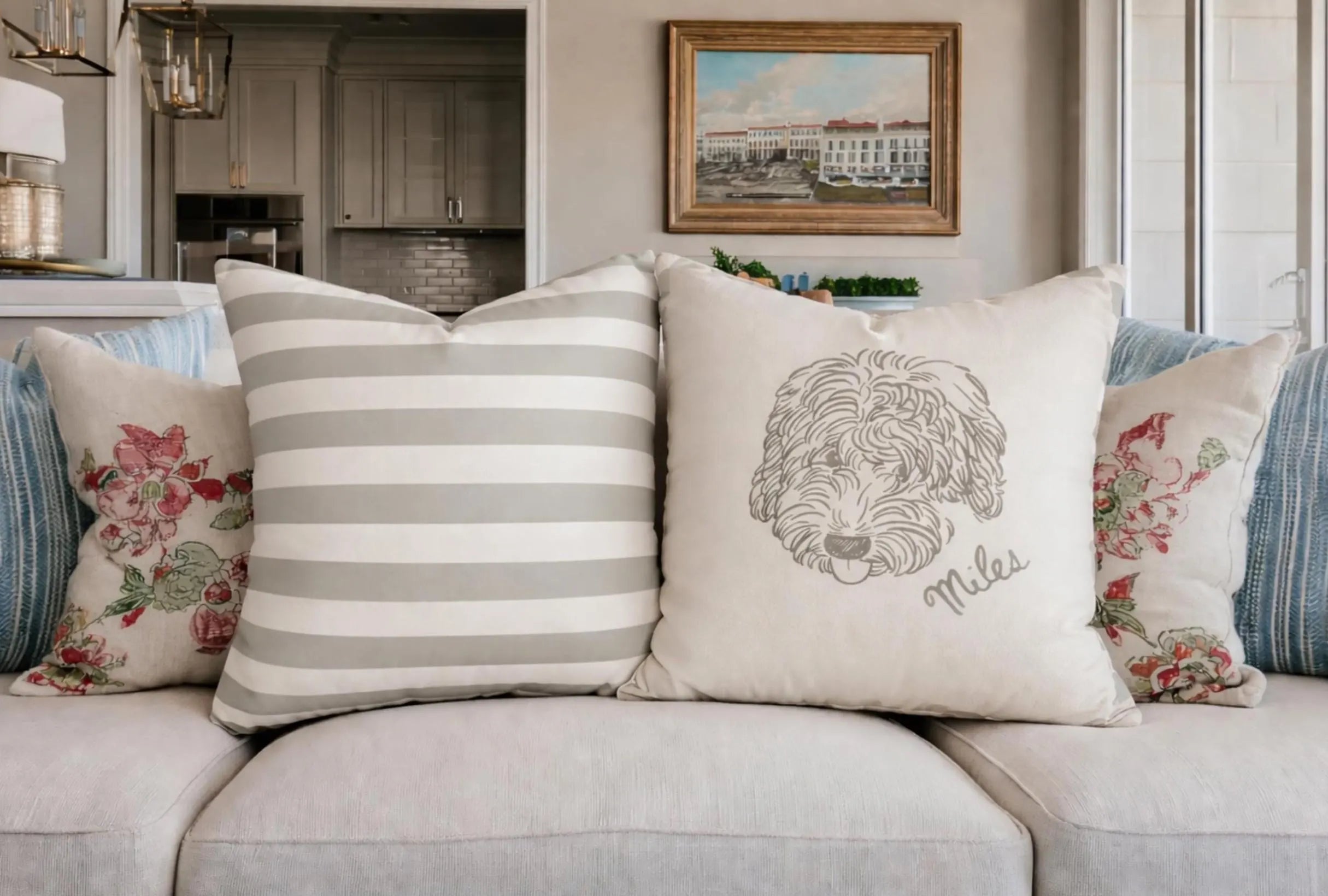 Decorative pillows with dog and text on a sofa with a painting in the background