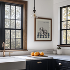 Modern kitchen with black windows, marble countertop, and framed artwork.