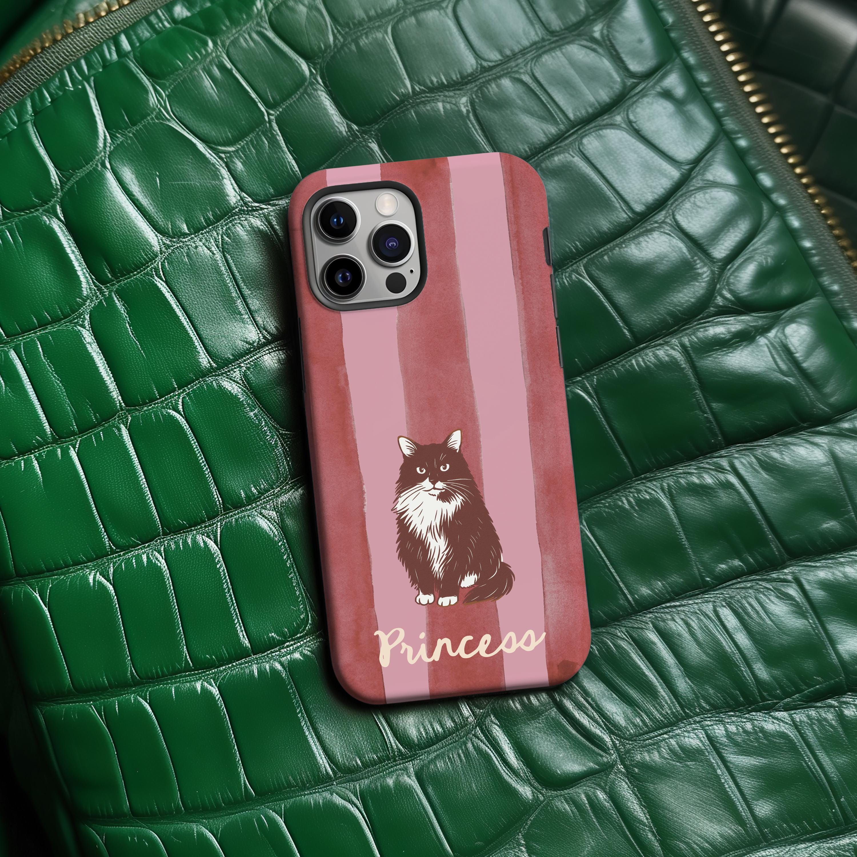 Pink striped Phone case with a cat illustration and 'Princess' text on a pink background, placed on a green textured surface.