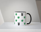 White mug with black handle featuring dog and clover pattern on a white background