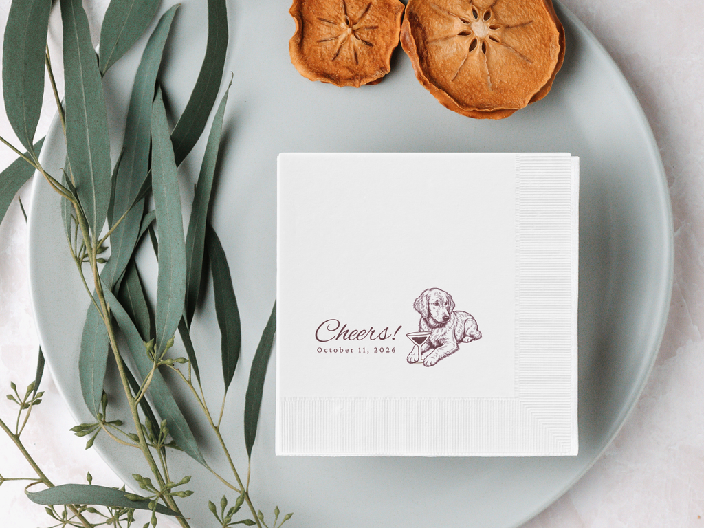 White napkin with a printed design on a gray plate with dried oranges and eucalyptus leaves.