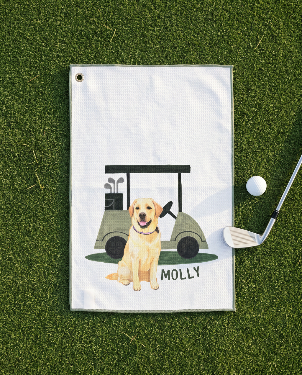 Golf towel with a yellow lab dog and golf cart illustration on a grass background