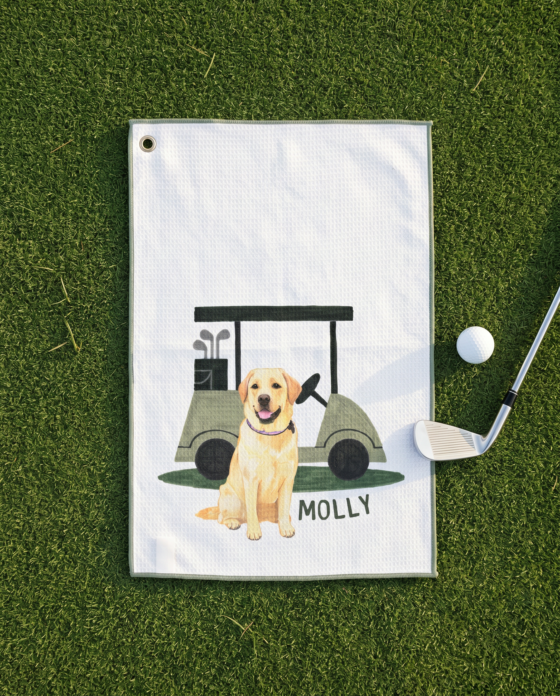 Golf towel with a yellow lab dog and golf cart illustration on a grass background